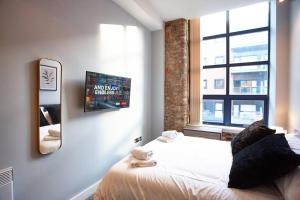 a bedroom with a bed with a mirror and a window at The Diamond Suite in Manchester