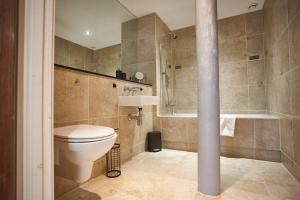 a bathroom with a toilet and a sink and a tub at The Diamond Suite in Manchester