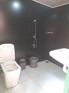 La salle de bains est pourvue de toilettes, d'une douche et d'un lavabo. dans l'établissement Wonderwoods Tent Camping Munnar, à Munnar