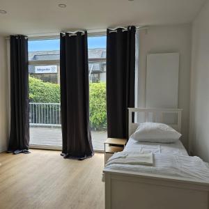 a bedroom with a bed and a large window at SFN Home Stay in Bergisch Gladbach