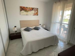 una camera da letto con un letto e un dipinto sul muro di Villa I Giardini del Conero con ombrellone in spiaggia a Porto Recanati
