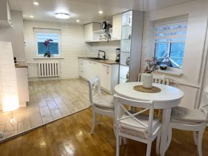 cocina con mesa blanca y sillas en una habitación en Dale's House in Birstonas en Birštonas
