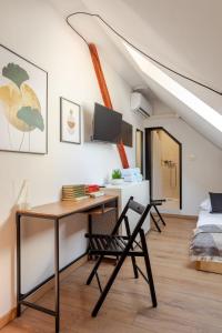 a desk and chairs in a room with an attic at Stylish Loft In The Hearth Of Historic Centre in Ljubljana