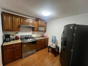 a kitchen with a black refrigerator and wooden cabinets at GR20acd Miguel Angel in Cuauhtémoc
