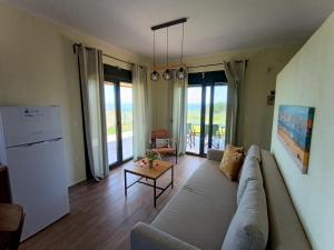 uma sala de estar com um sofá e uma mesa em Pezoulia Cottages em Samothráki