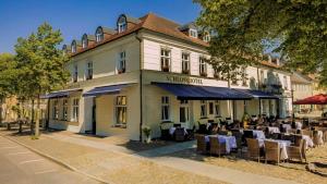 a restaurant with tables and chairs in front of a building at Schlosshotel Rheinsberg in Rheinsberg