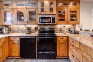 a kitchen with wooden cabinets and a black dishwasher at SNOW FLOWER 029 condo in Park City