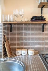eine Küchentheke mit Gläsern, Tellern und einer Spüle in der Unterkunft Villa LaBelle Vera in Vodice