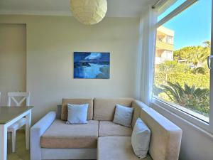 sala de estar con sofá y ventana grande en Sunflower Apartment With Garden - 180, en Durrës