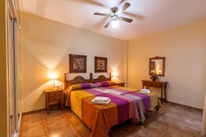 - une chambre avec un lit et un ventilateur de plafond dans l'établissement Apartamentos La Casa del Barrio, à Maro