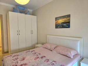 1 dormitorio con 1 cama y armario blanco en Sunflower Apartment With Garden - 180, en Durrës