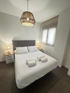 Un dormitorio con una cama con dos toallas encima. en Coello31 - Apartamento céntrico y tranquilo, con piscina y parking, en Jaén