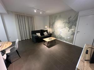 una sala de estar con un sofá y una mesa en Coello31 - Apartamento céntrico y tranquilo, con piscina y parking, en Jaén
