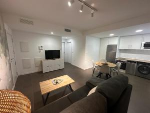 a living room with a couch and a table at Coello31 - Apartamento céntrico y tranquilo, con piscina y parking in Jaén
