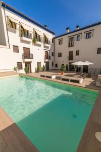 a large swimming pool in front of a building at Coello31 - Apartamento céntrico y tranquilo, con piscina y parking in Jaén