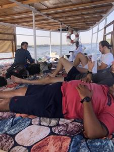 eine Gruppe von Menschen, die auf dem Boden eines Bootes sitzen in der Unterkunft King of love in Luxor