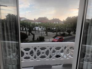 a balcony with a red car on a city street at Apartamento Café Teatro in Arzúa