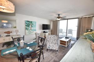 uma sala de estar com uma mesa de vidro e cadeiras em 0804 Waters Edge Resort condo em Myrtle Beach