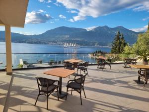 un patio con mesas y sillas y vistas al lago en Agape Rose, en Tivat