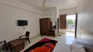 Pokój z łóżkiem, telewizorem i biurkiem w obiekcie Hotel Mayur Inn w mieście Udaipur
