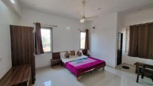 a bedroom with a bed with a purple blanket at Hotel Mayur Inn in Udaipur