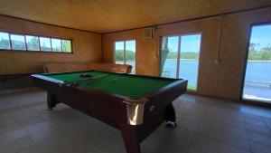 a pool table in a room with a view of the water at Ośrodek wczasowy Raciąż in Raciąż