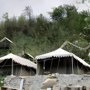 馬拉里的住宿－Welstays Gadherni Waterfalls，两顶白色帐篷,位于一座树木繁茂的山丘前
