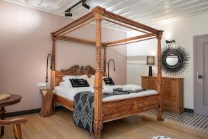 a wooden canopy bed in a bedroom with a mirror at Vranas Ambiance Hotel in Chania Town