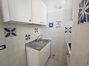 a small kitchen with a sink and blue and white tiles at Maridea - O'Sarracino in Ponza +2 photos