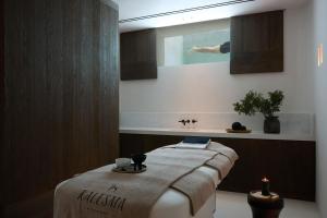 uma sala de spa com uma cama e um lavatório em Kalesma Mykonos em Ornos