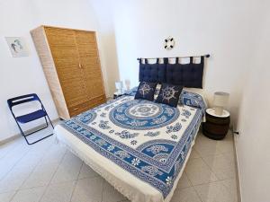a bedroom with a bed with a blue and white comforter at Maridea - O'Sarracino in Ponza