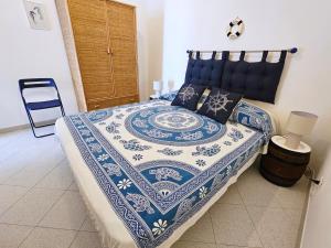 a bedroom with a bed with a blue and white quilt at Maridea - O'Sarracino in Ponza