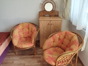 two chairs and a mirror in a room at Apartmany Fantagiro in Kaluža