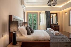 Vranas Ambiance Hotel في مدينة خانيا: غرفة نوم بسرير كبير عليها شراشف ووسائد بيضاء