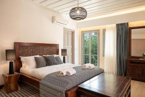 Vranas Ambiance Hotel في مدينة خانيا: غرفة نوم بسرير كبير عليها مناشف