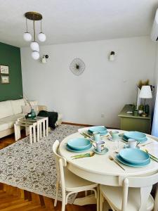 ヴィソコにあるCozy Suite Apartmentのリビングルーム(青い皿のあるテーブル付)