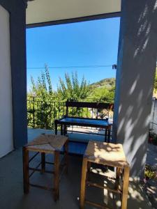 a pair of stools and a table on a balcony at Θέα Αιγαίου in Karavostamo