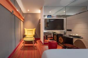 a room with a yellow chair and a television at WISDOM Boutique Hotel in Beijing