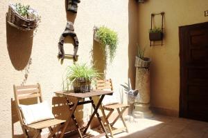 a patio with a table and chairs and potted plants at Casa Rural Bellamonte in Belmonte