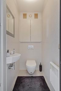 Un baño blanco con inodoro y lavabo. en Luxe apartement Zeedijk 122, en Nieuwpoort