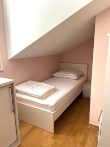 een bed in een kleine kamer onder een dak bij The Sun Terrace Apartment Rogoznica in Rogoznica