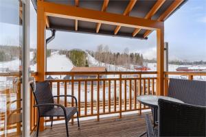 un porche con sillas y una mesa en una terraza con nieve en KungsbergetNatur, en Järbo