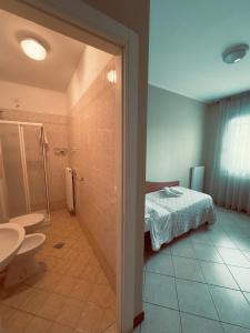 y baño con cama, ducha y aseo. en Albergo Trattoria Friulana AL TAJ, en Sevegliano