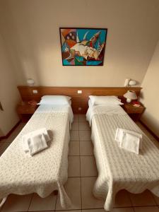 a room with two beds and a painting on the wall at Albergo Trattoria AL TAJ in Sevegliano