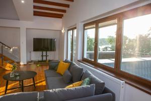 a living room with a couch and a television at Apartamenty Jeziorna 40 in Charzykowy