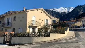 une maison dans une rue avec des montagnes en arrière-plan dans l'établissement Albizia, à Vernet-les-Bains