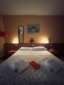 1 dormitorio con 1 cama con 2 toallas en Albergo Trattoria Friulana AL TAJ, en Sevegliano