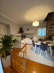 een keuken en een woonkamer met een tafel en stoelen bij Lori House in Corfu. Feel like your home in Skriperón
