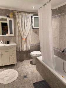 een badkamer met een toilet, een bad en een wastafel bij Lori House in Corfu. Feel like your home in Skriperón