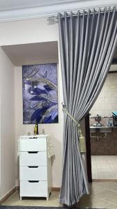una habitación con una cortina, un tocador y una pintura en Cozy Nile view apartment en Asiut